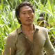 Daniel Dae Kim standing in a field and looking sweaty as his character in Lost.